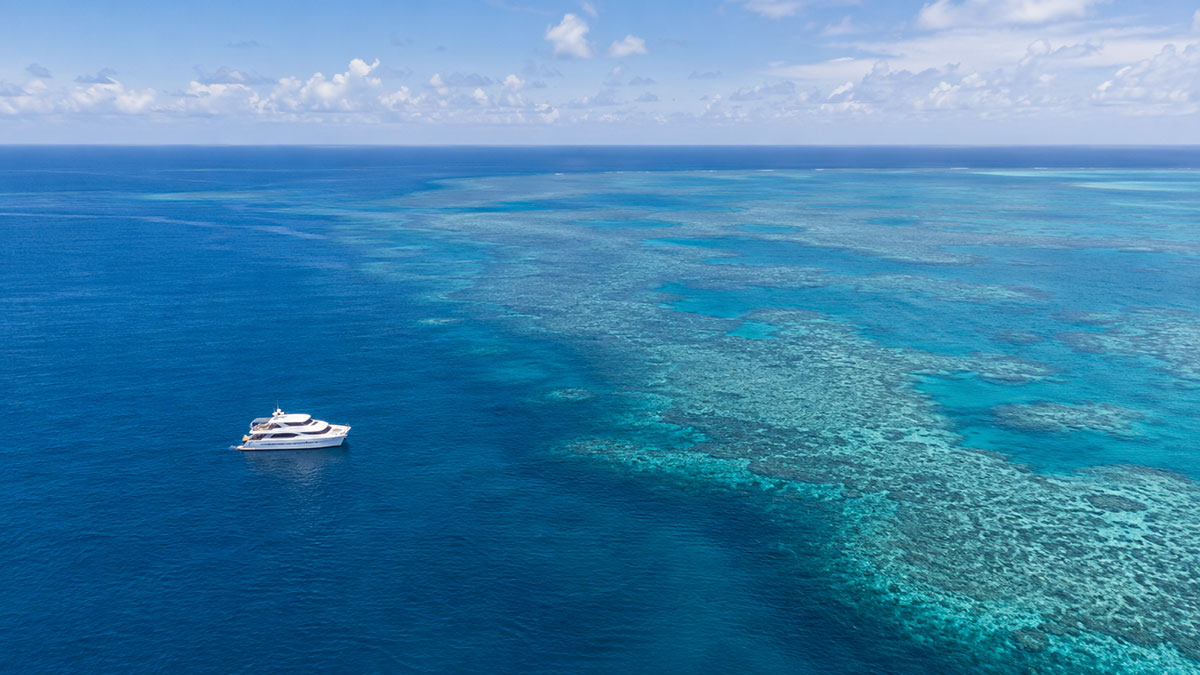Vista aerea della Grande Barriera Corallina con imbarcazione turistica al largo di Cairns