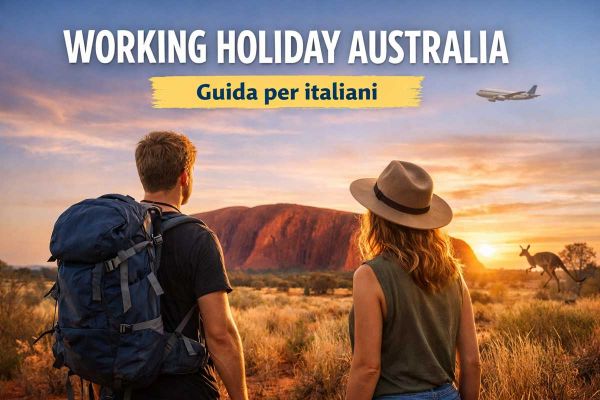 Due giovani viaggiatori davanti a Uluru al tramonto durante un Working Holiday in Australia